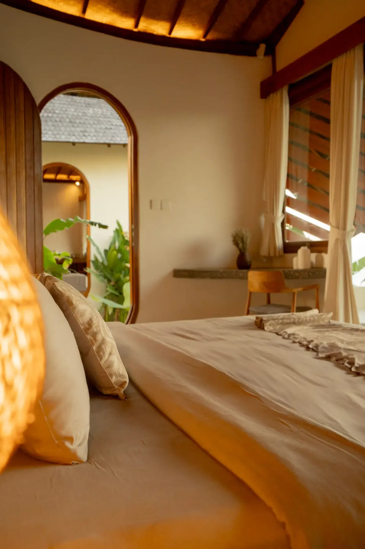 Serene bedroom with arched mirror and tropical garden view at Elysian Cove accommodation