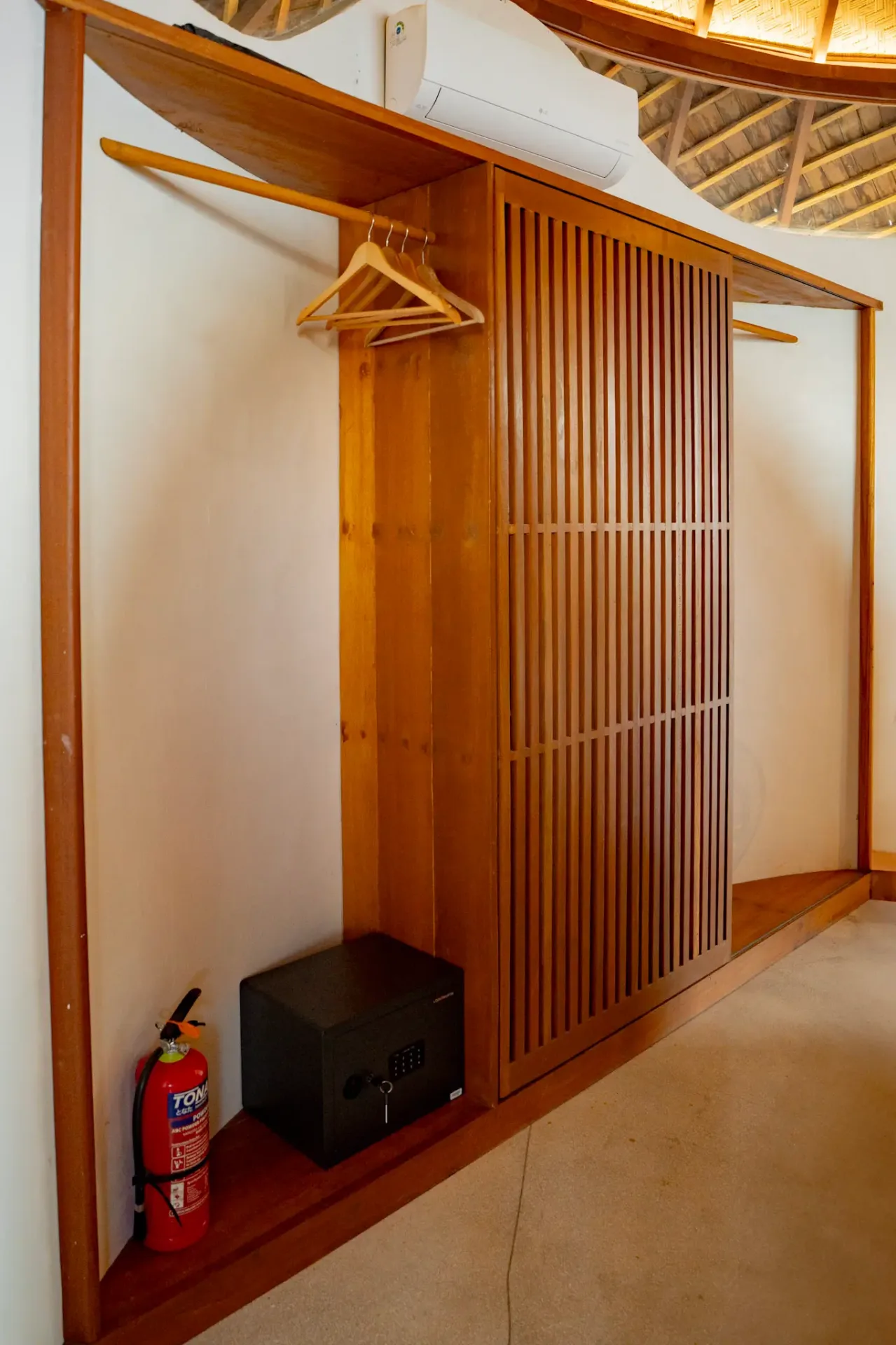 Built-in wooden wardrobe with sliding doors at Elysian Cove hotel room