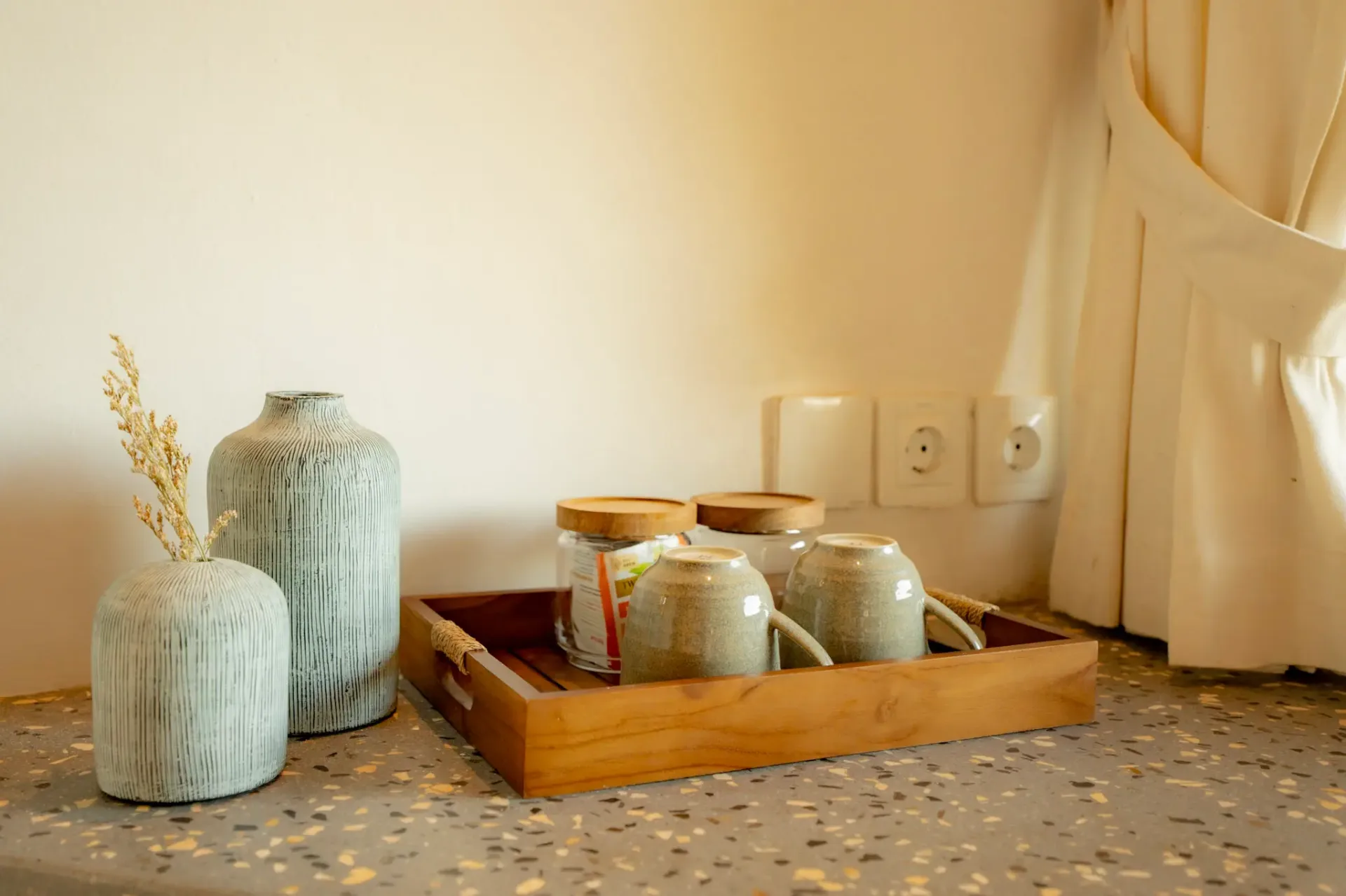 Elegant tea set and decorative vases on terrazzo countertop at Elysian Cove accommodation