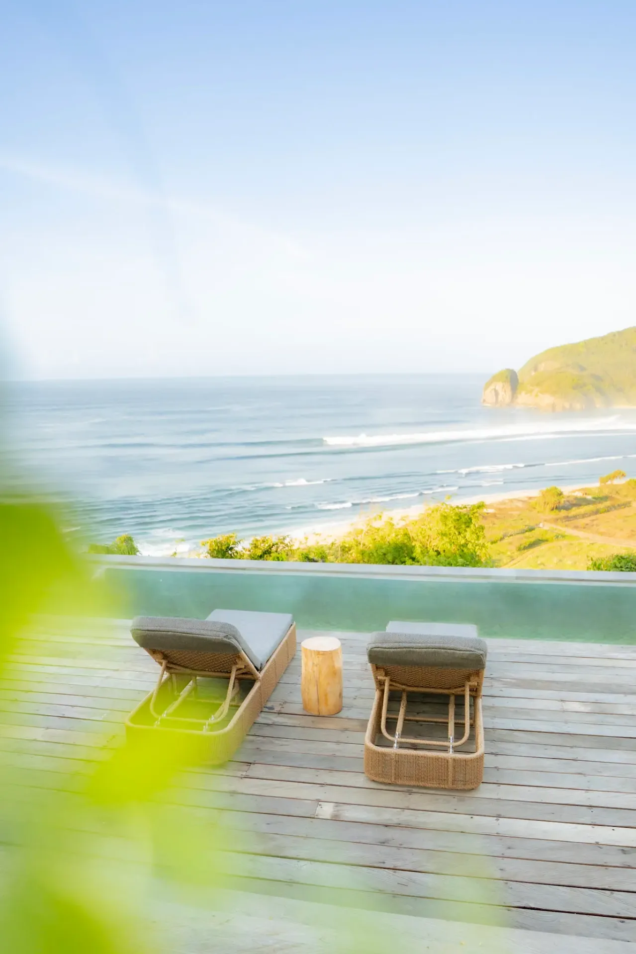 Infinity pool deck with ocean view loungers overlooking beach at luxury Elysian Cove resort