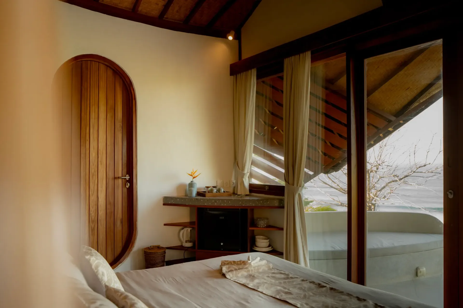 Cozy bedroom interior with ocean view terrace at Elysian Cove boutique hotel in Sumbawa