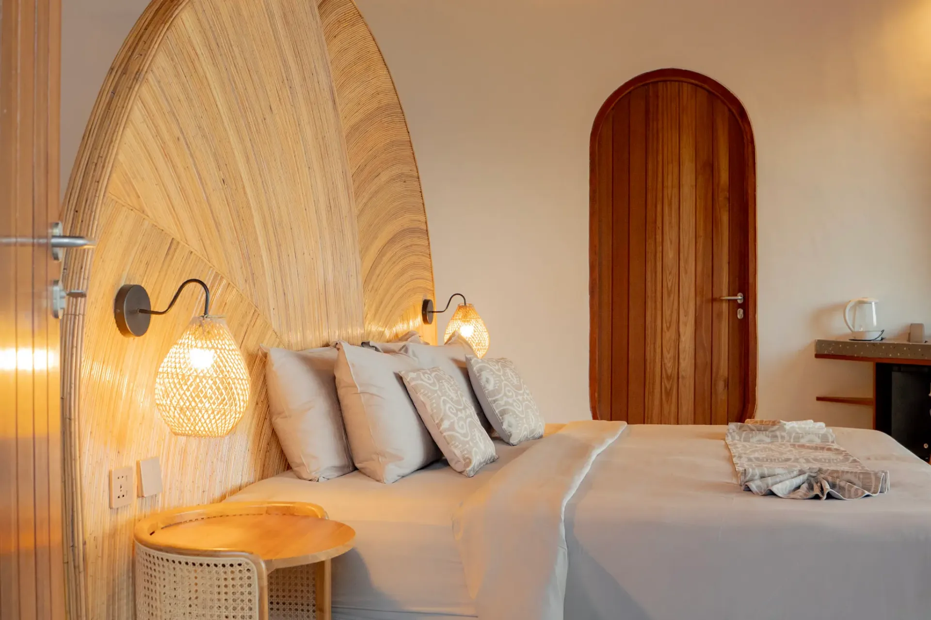 Luxurious bedroom with natural fiber headboard and ambient lighting at Elysian Cove hotel