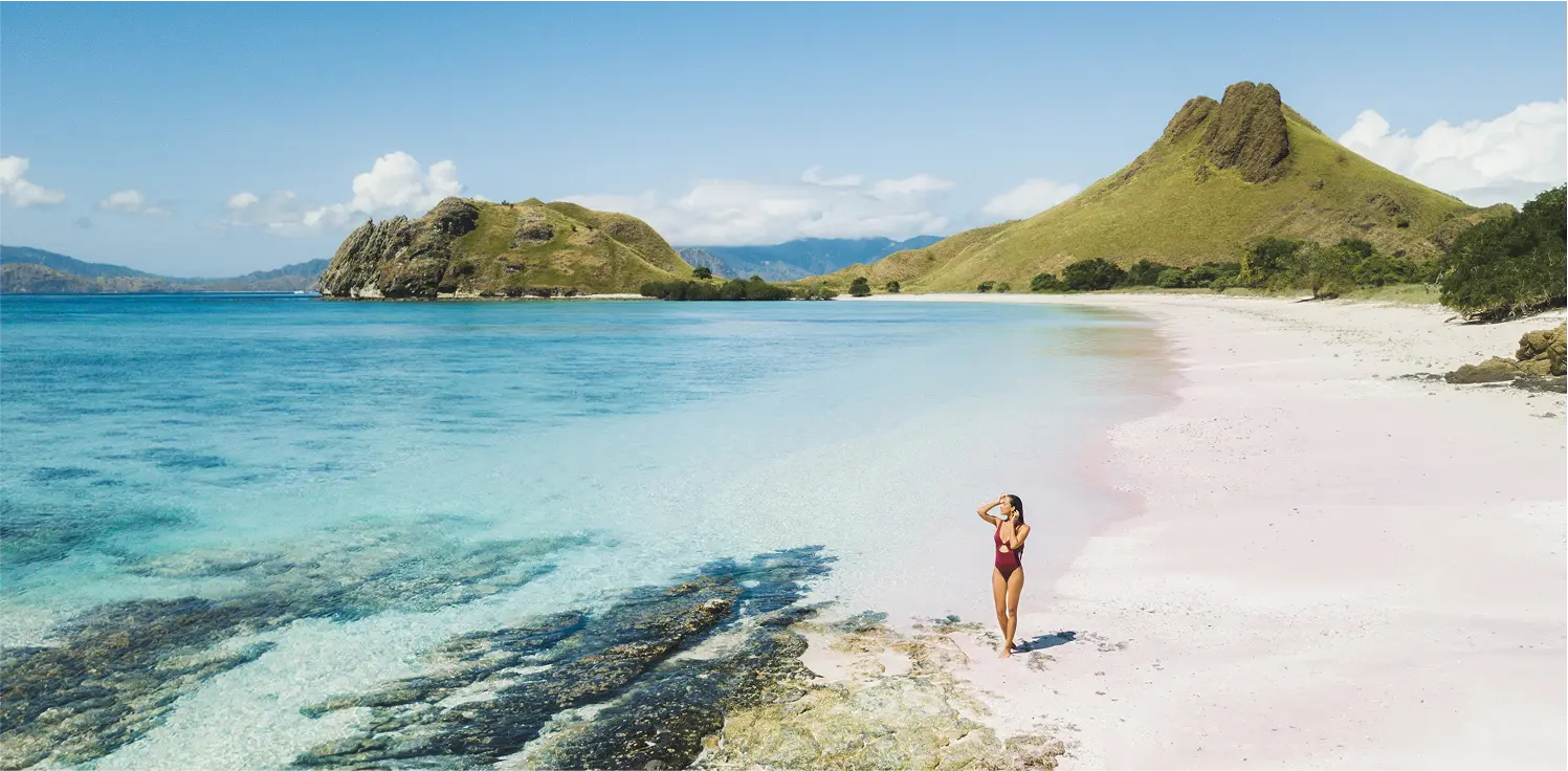 Pristine tropical beach with turquoise waters and lush green hills in Sumbawa